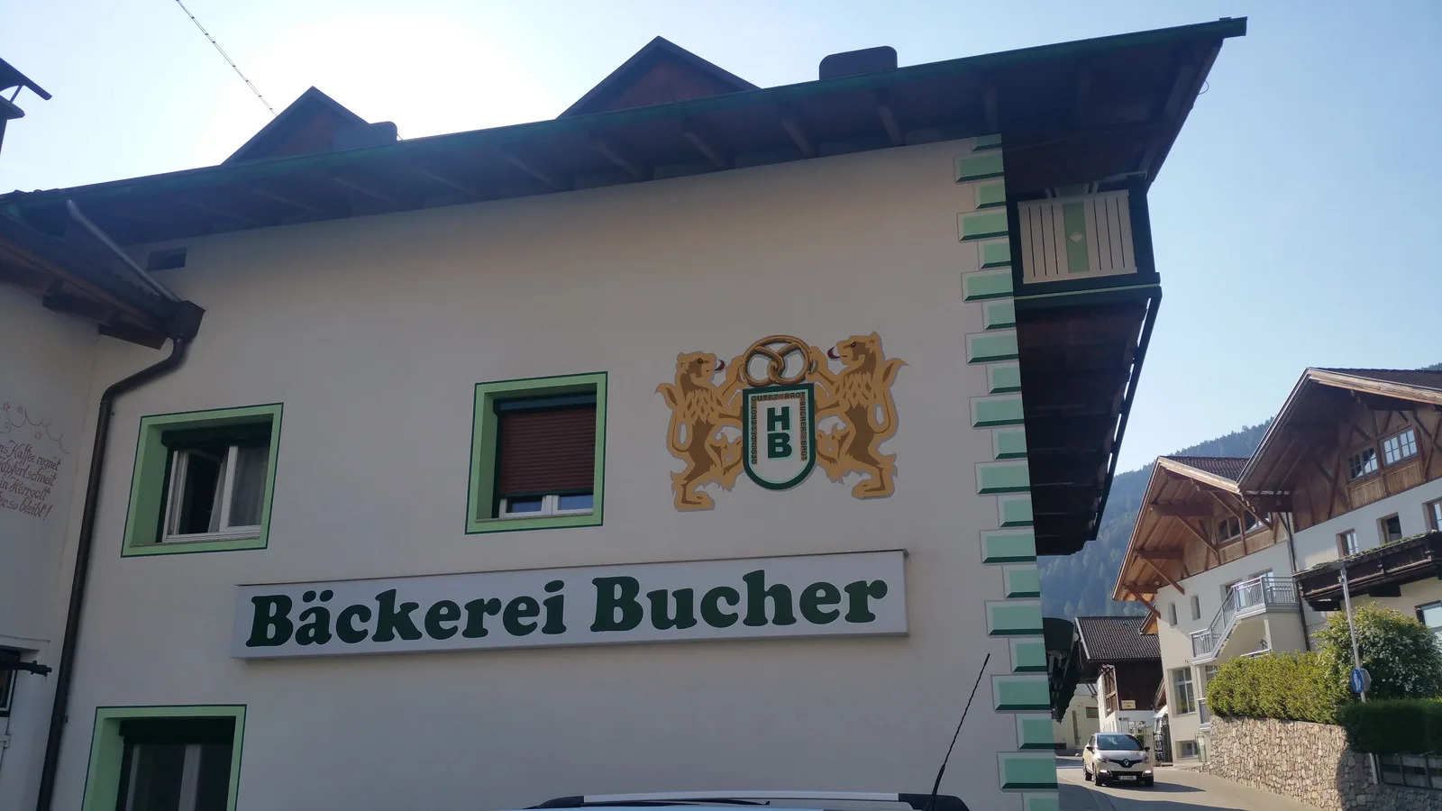 Giebelwand der Bäckerei Bucher mit dem großen Familienwappen und dem grünen Schriftzug Bäckerei Bucher