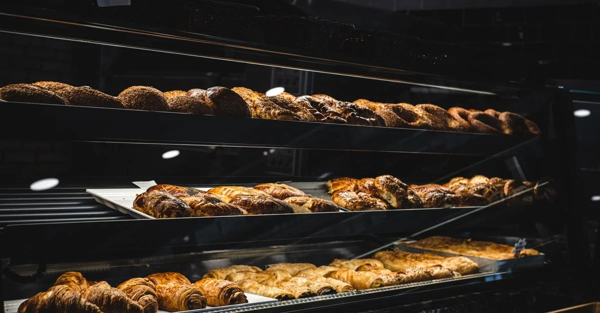 Auslage einer Bäckerei mit Plundergebäck und Gebäckstangen auf mehreren Ebenen